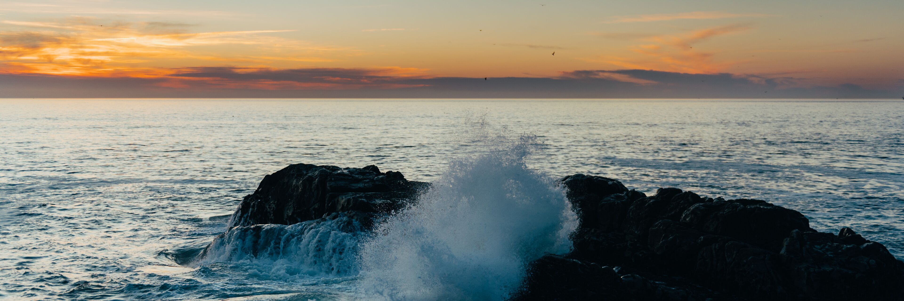Waves of the Atlantic Ocean during sunset, beautiful strong waves with splashes near rocky beach, banner size