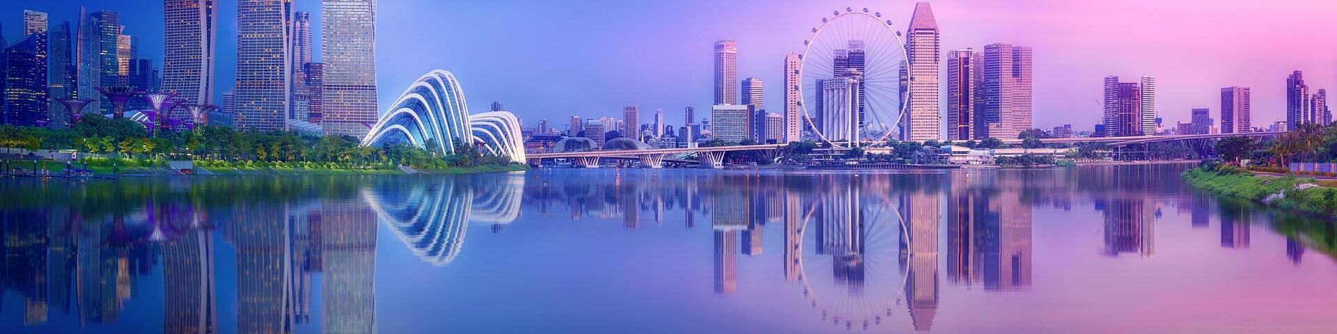 Silhueta urbana com arquitetura moderna, incluindo uma ponte marcante e uma grande roda-gigante.