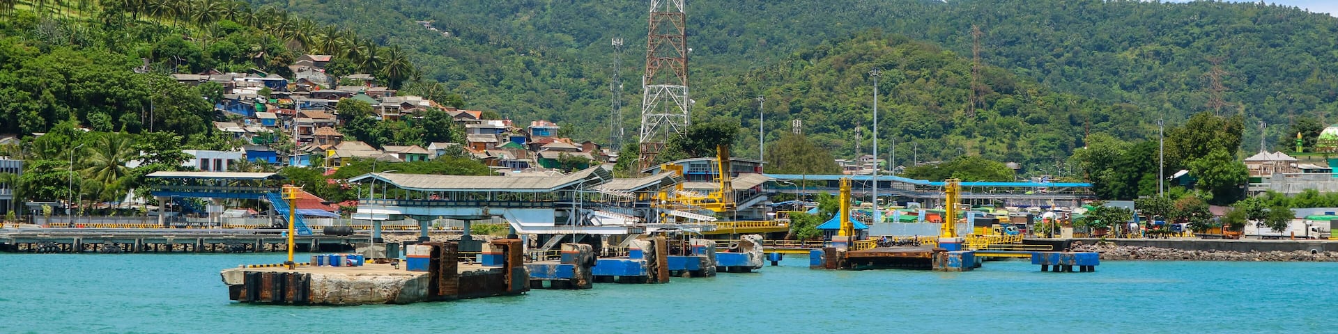 Panoramic view of harbor or port with communication or provider tower and village on hillside. Merak port in Banten, Indonesia.