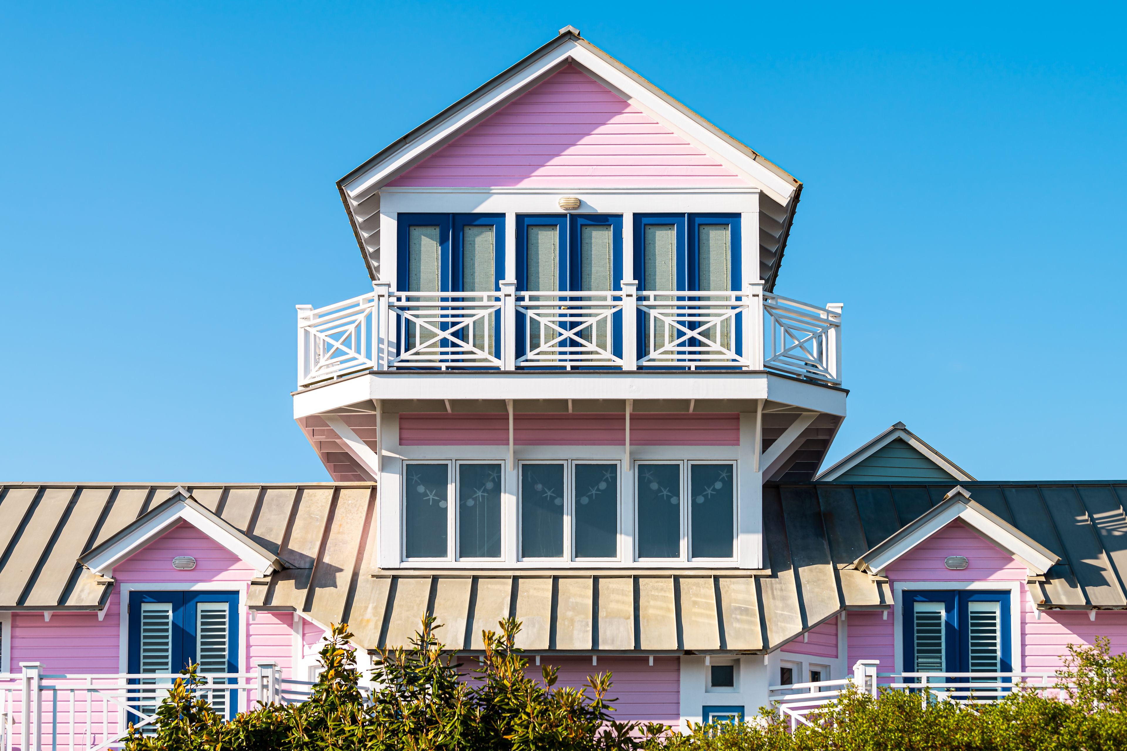 Wooden house tower architecture by beach ocean nobody in Florida view during sunny day with pink color of new urbanism design and blue sky