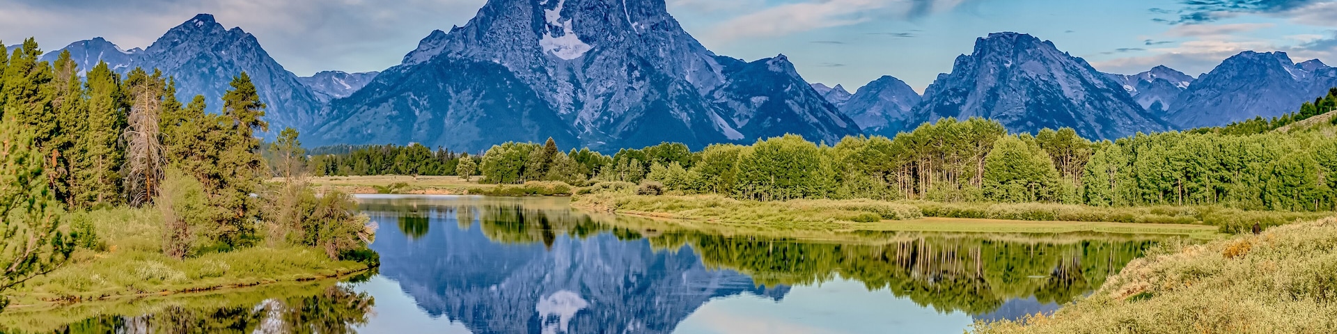 A mountain range, a calm lake, and a forested area.