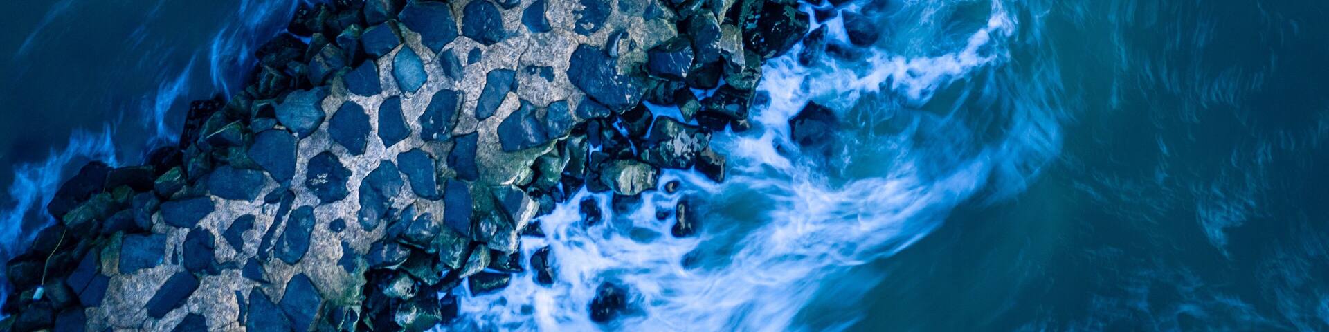 A rocky shoreline with waves crashing against it.
