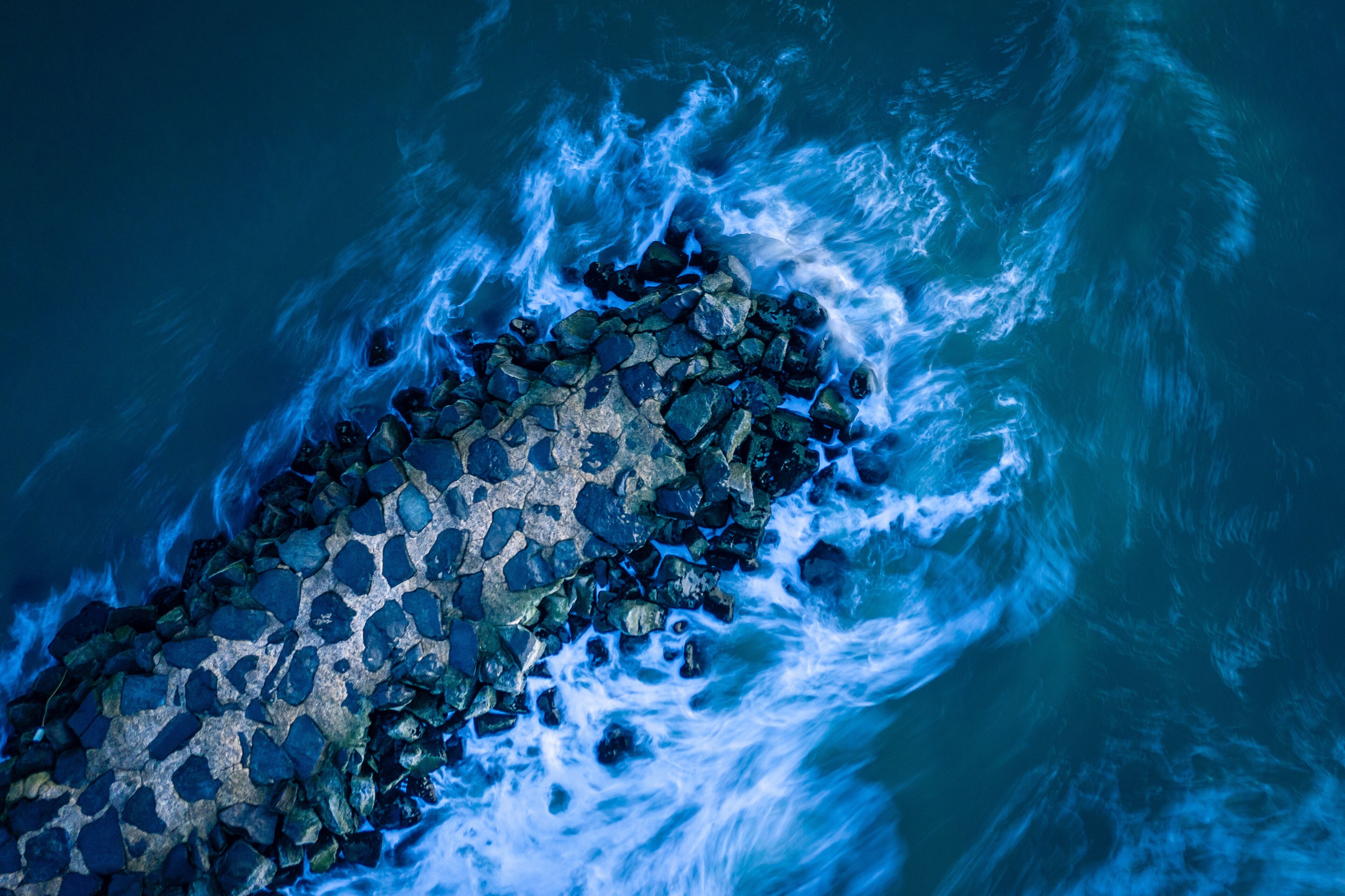 A rocky shoreline with waves crashing against it.