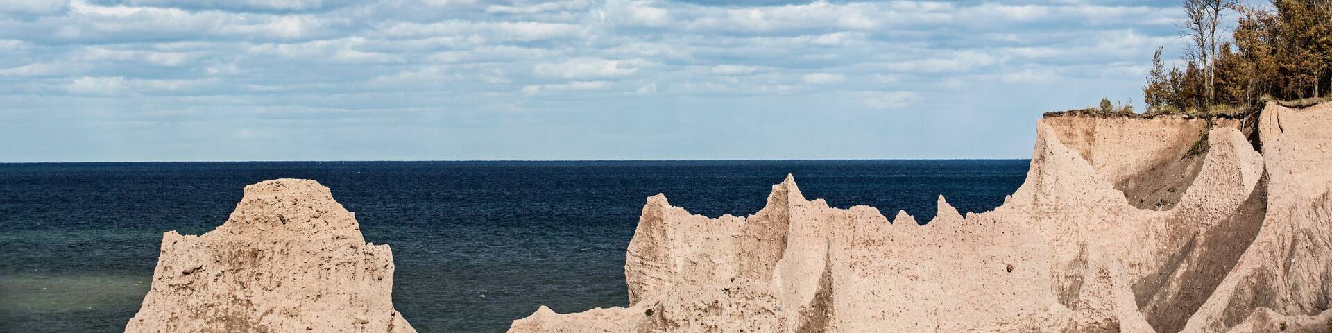 A coastal landscape with rugged cliffs and a clear sky.