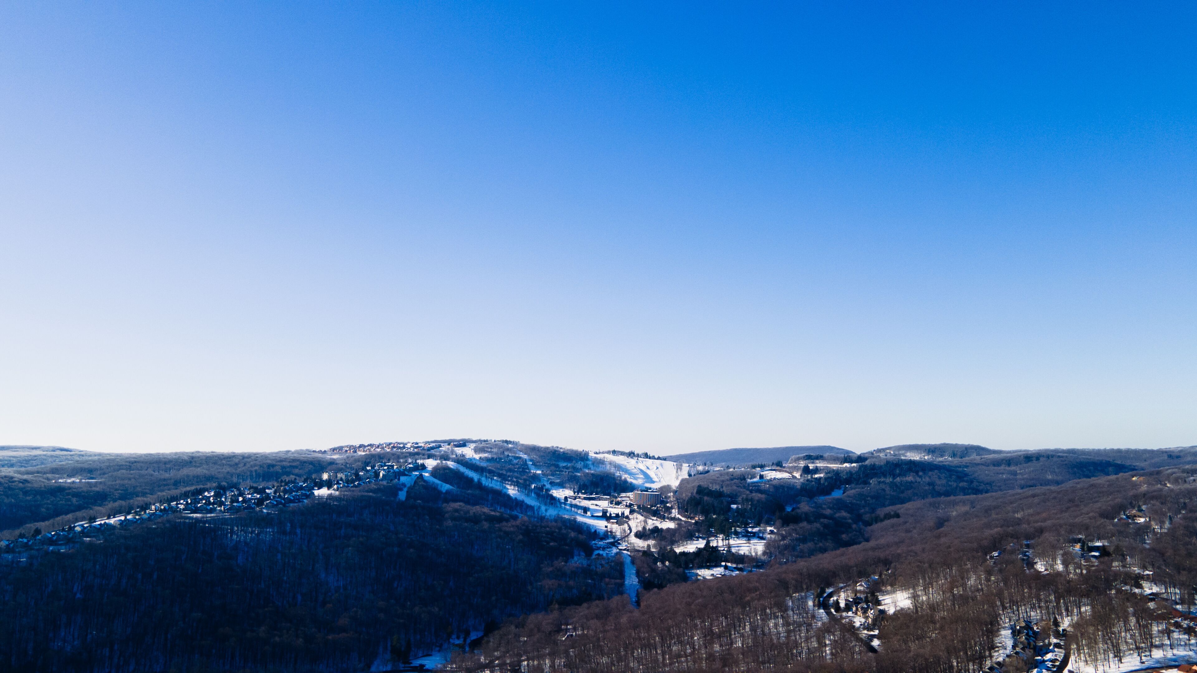 A snow-covered mountain landscape with a clear blue sky.