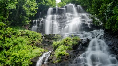 A multi-tiered waterfall surrounded by lush greenery.