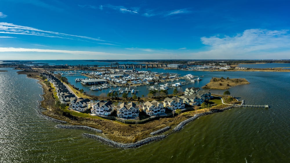 Aerial sunny winter view of luxury duplex residential neighborhood on a manmade promontory with luxury sail boats docked in the marina at Kent Island Narrows Maryland USA