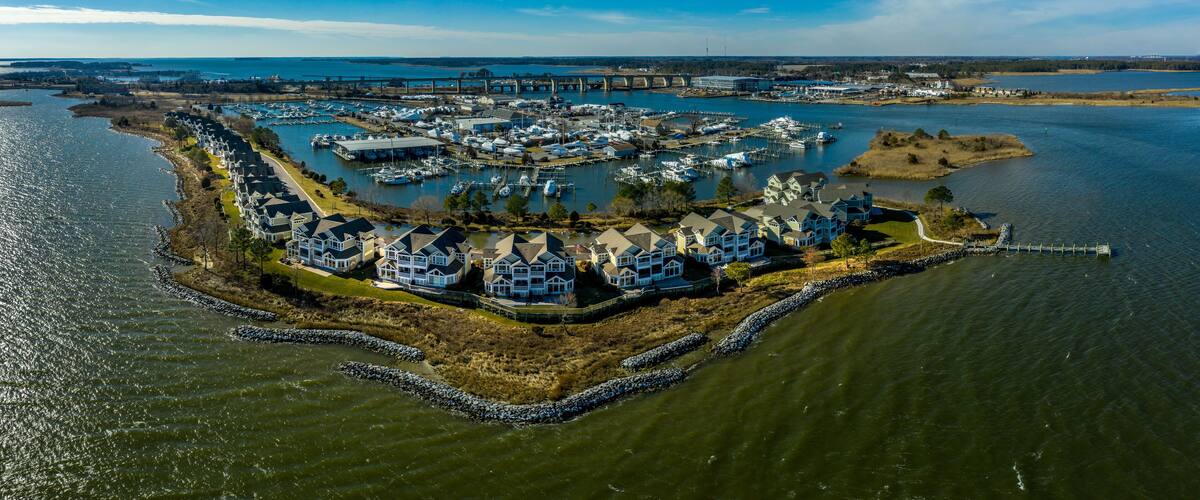 Aerial sunny winter view of luxury duplex residential neighborhood on a manmade promontory with luxury sail boats docked in the marina at Kent Island Narrows Maryland USA