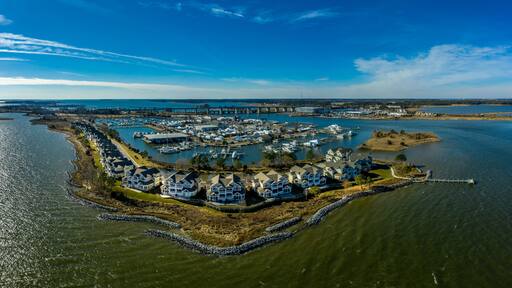 Aerial sunny winter view of luxury duplex residential neighborhood on a manmade promontory with luxury sail boats docked in the marina at Kent Island Narrows Maryland USA