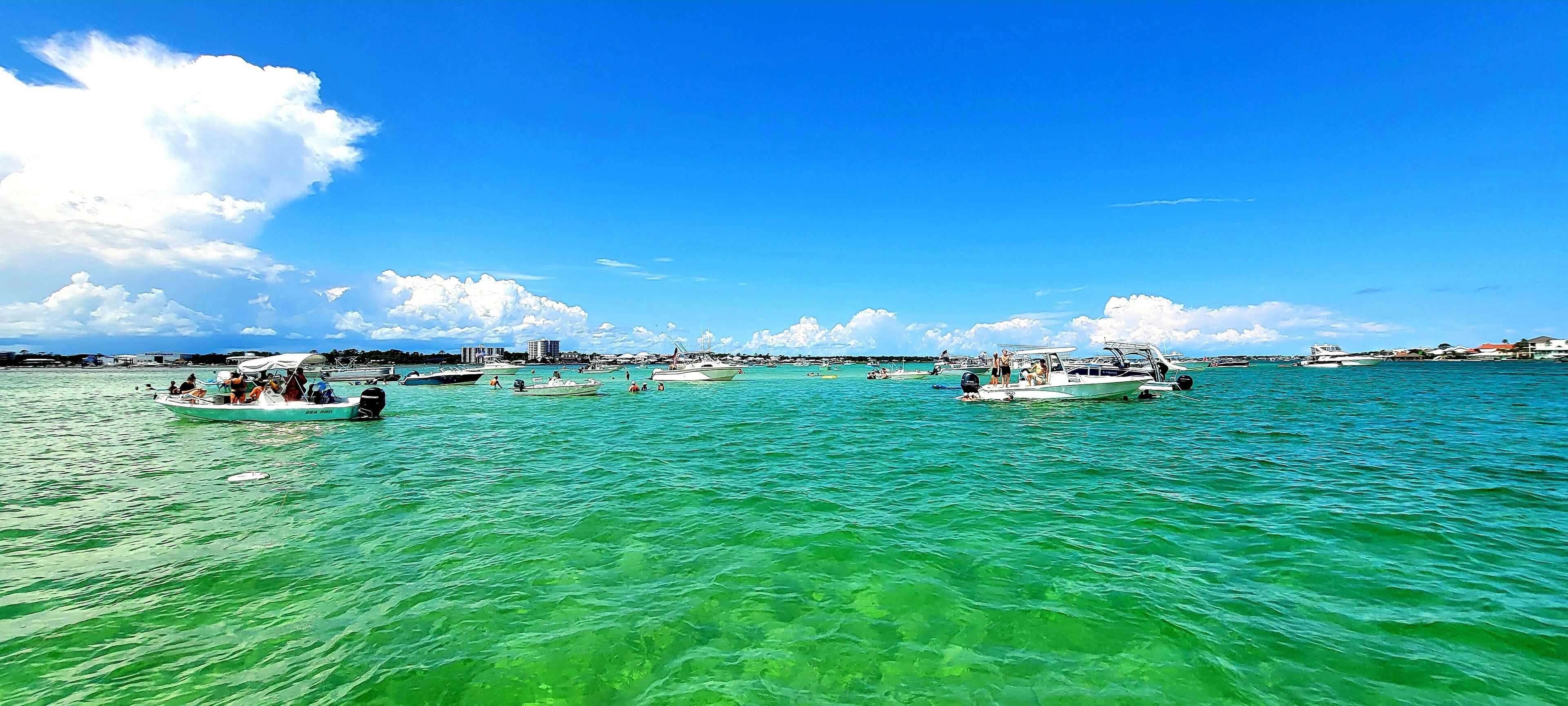 A marina with several boats docked and people on the water.