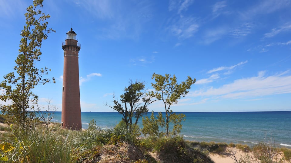 A lighthouse by the sea with clear skies.