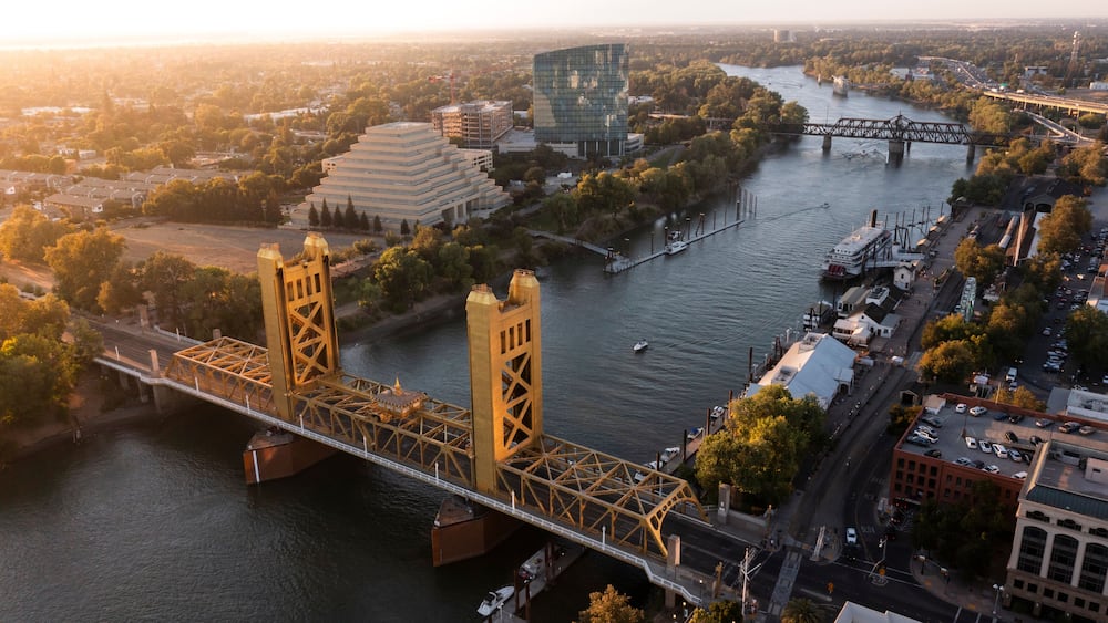 A river with a bridge, buildings, and a riverboat.