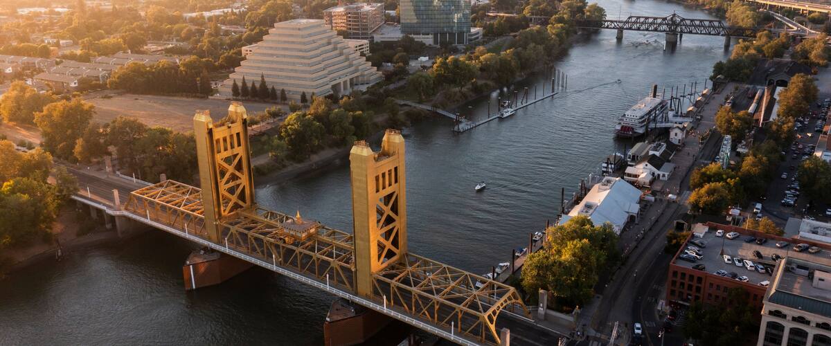 A river with a bridge, buildings, and a riverboat.