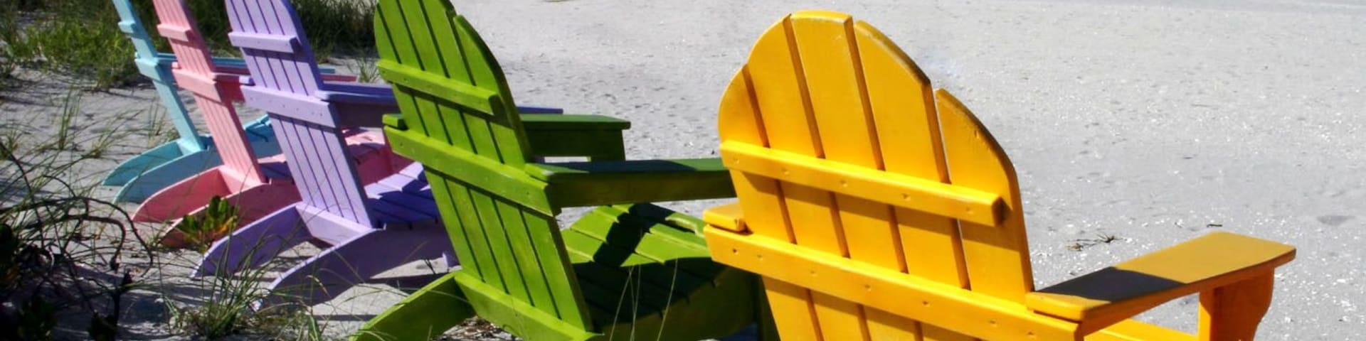 Colorful adirondack chairs on Captiva Island Florida with the Gulf of Mexico in the background