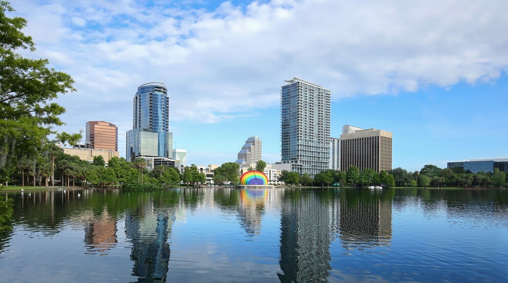 Downtown Orlando skyline glistens as it reflects in the clean waters of Lake Eola. Lake Eola Park is a popular downtown tourist attraction.