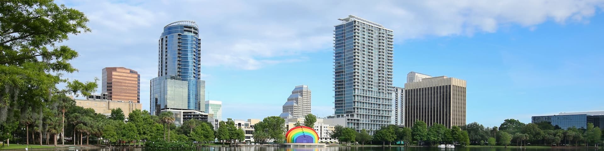 Downtown Orlando skyline glistens as it reflects in the clean waters of Lake Eola. Lake Eola Park is a popular downtown tourist attraction.