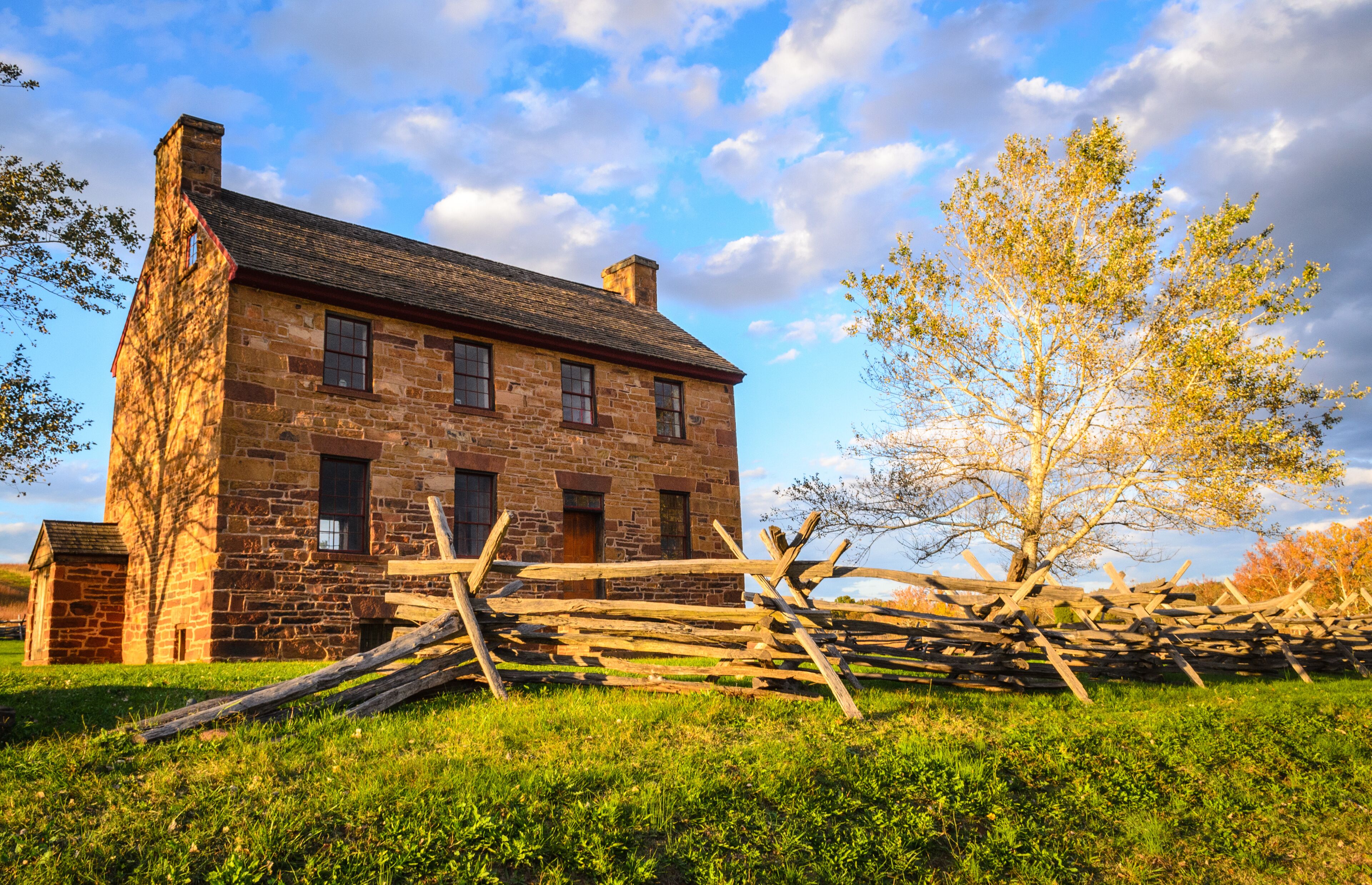 A stone building with a wooden fence in front.