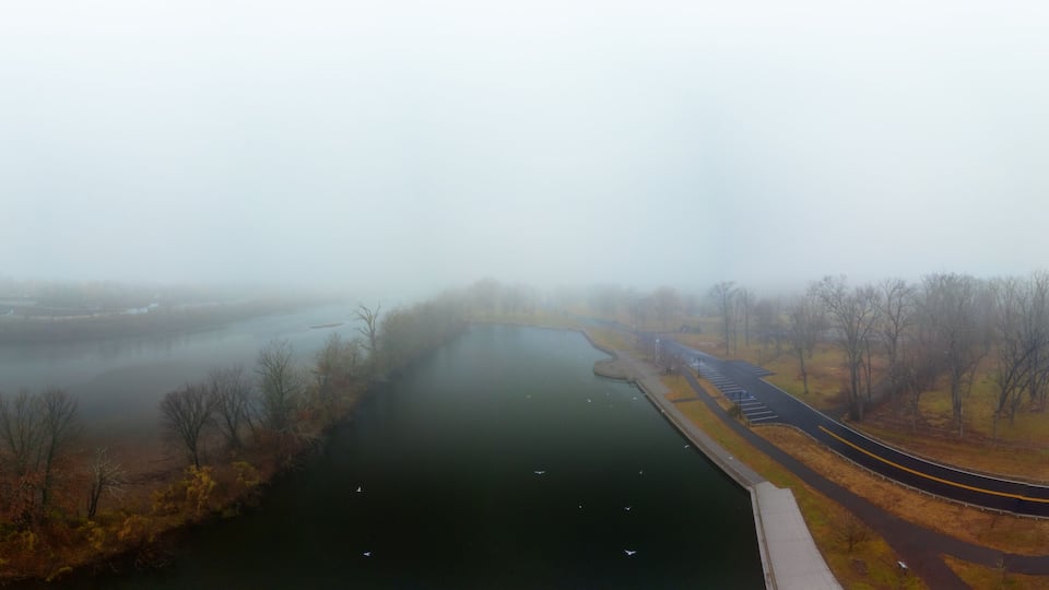 A river with a bridge and a parking lot.