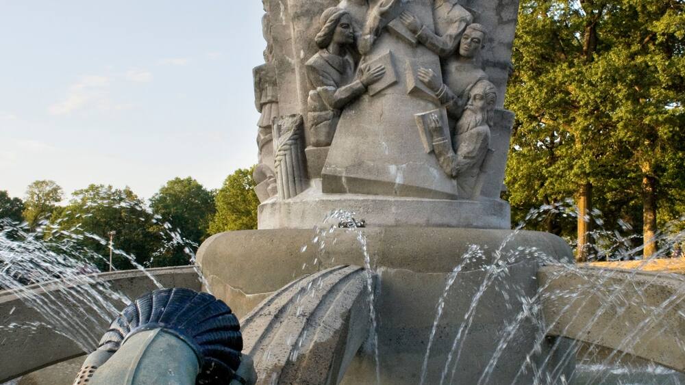 A fountain with a globe and sculptures of people.
