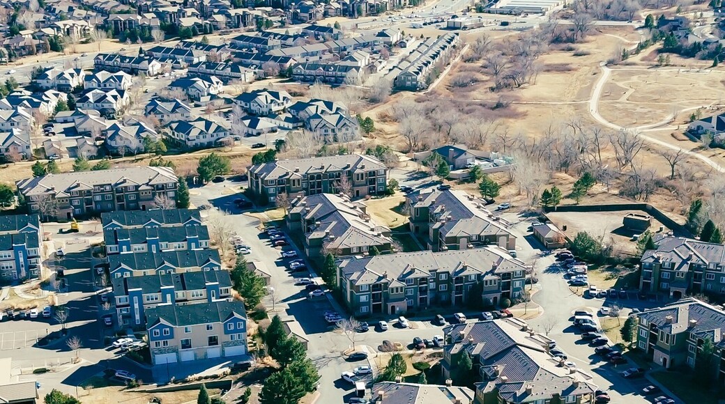 Panorama view residential blocks south of E Arapahoe Rd align with nearby access roads extending toward E 470. Varied roof palettes, parked vehicles, seasonal foliage patterns across Aurora, CO