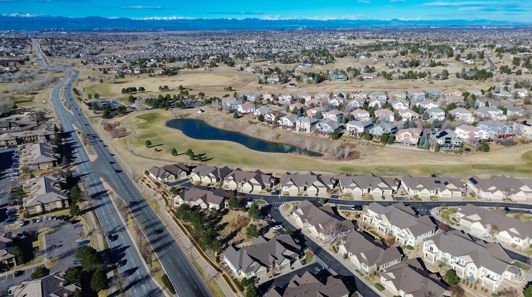 Homes surrounding Saddle Rock Golf Course extend toward E Arapahoe Rd with clear fairway boundaries. Light roofing, dormant greens, scattered trees create calm seasonal patterns, Aurora, CO