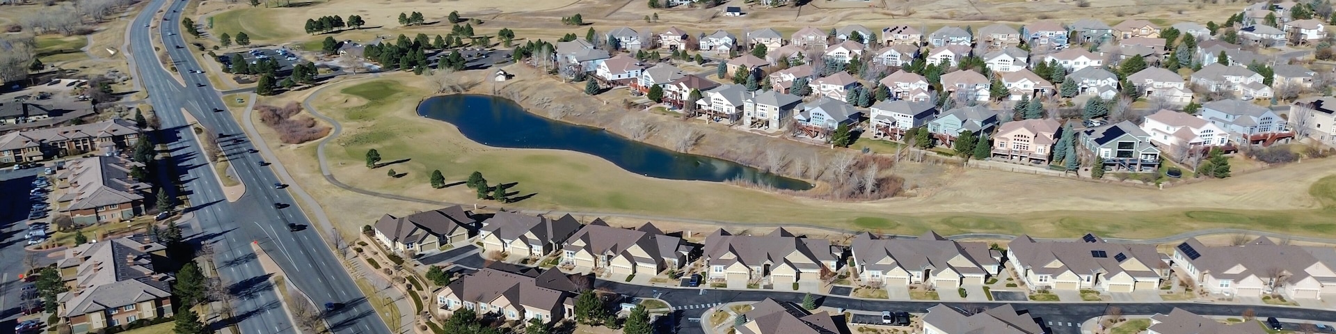 Homes surrounding Saddle Rock Golf Course extend toward E Arapahoe Rd with clear fairway boundaries. Light roofing, dormant greens, scattered trees create calm seasonal patterns, Aurora, CO