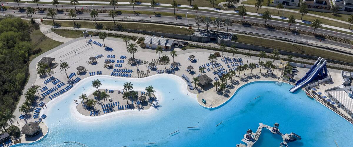 Wesley Chapel, United States - 02 March 2026: Aerial view of Epperson Lagoon featuring turquoise water, white sand beaches, palm trees, and water slides.