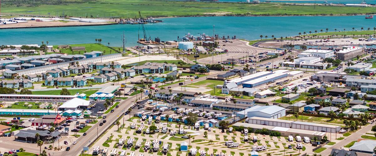 An industrial area with a marina, shipping containers, and a large body of water.