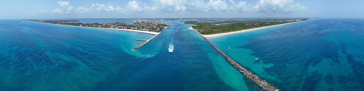 Aerial panorama view of boat heading to sea in Fort Pierce Inlet on the Treasure Coast of Florida in St. Lucie County