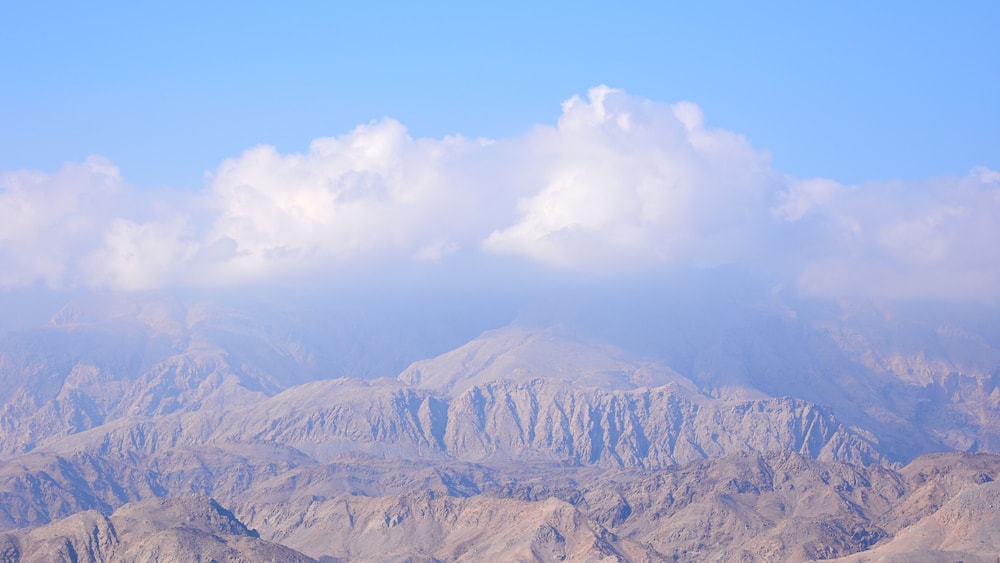A mountainous landscape with a clear sky and a body of water in the foreground.
