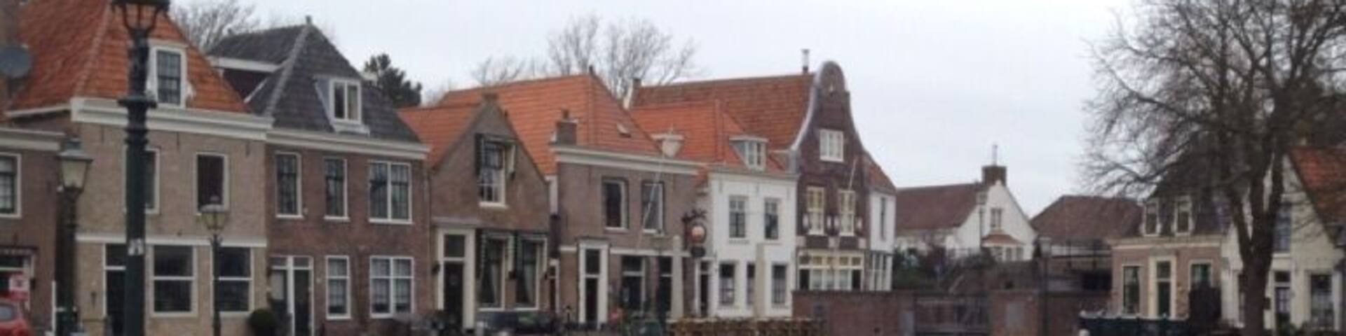 A canal with traditional European-style buildings on one side and a brick pathway on the other.