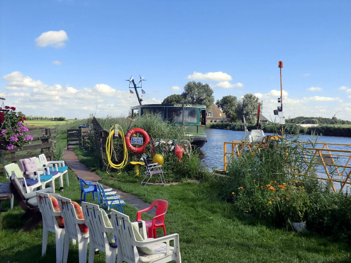 #Colorful open-air ferry stop.

We were cycling in Friesland, following the bicycle path crossing polders and green fields. The path stopped right here in front of the canal, which has to be crossed with this pontje (ferry for walkers and bikers) and its lovely captain. This was a good excuse to have a break and shows how good the bicycle path system is in the Netherlands.
#bicycle