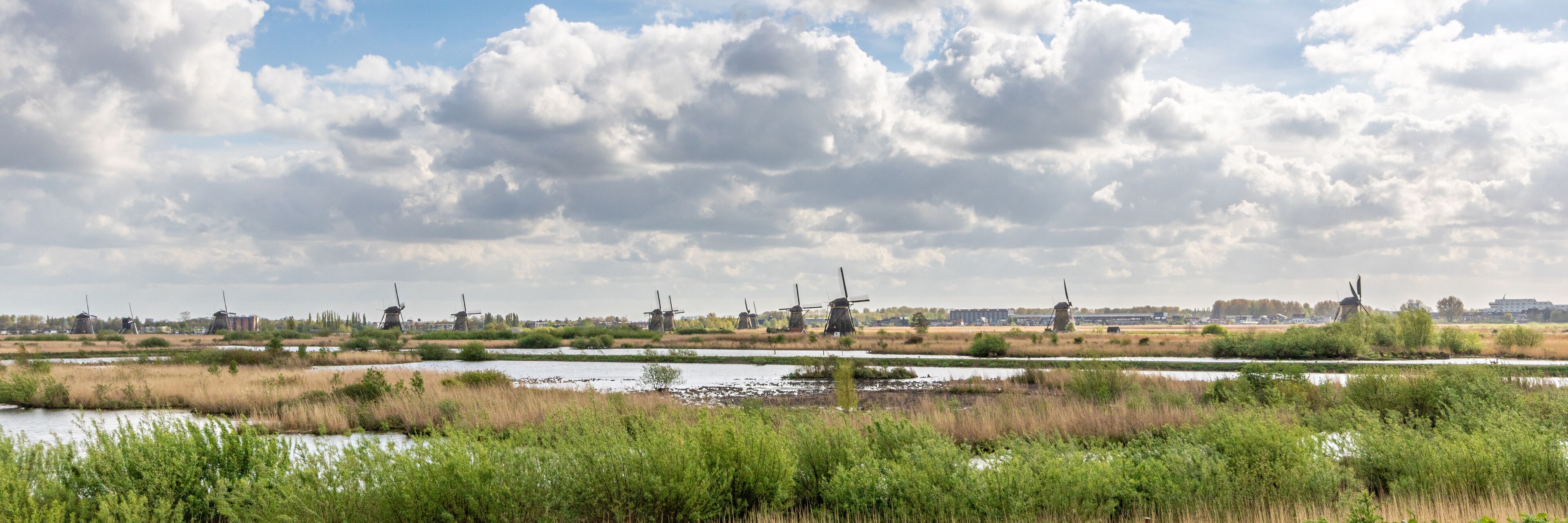 Windmills, water, and a cloudy sky.