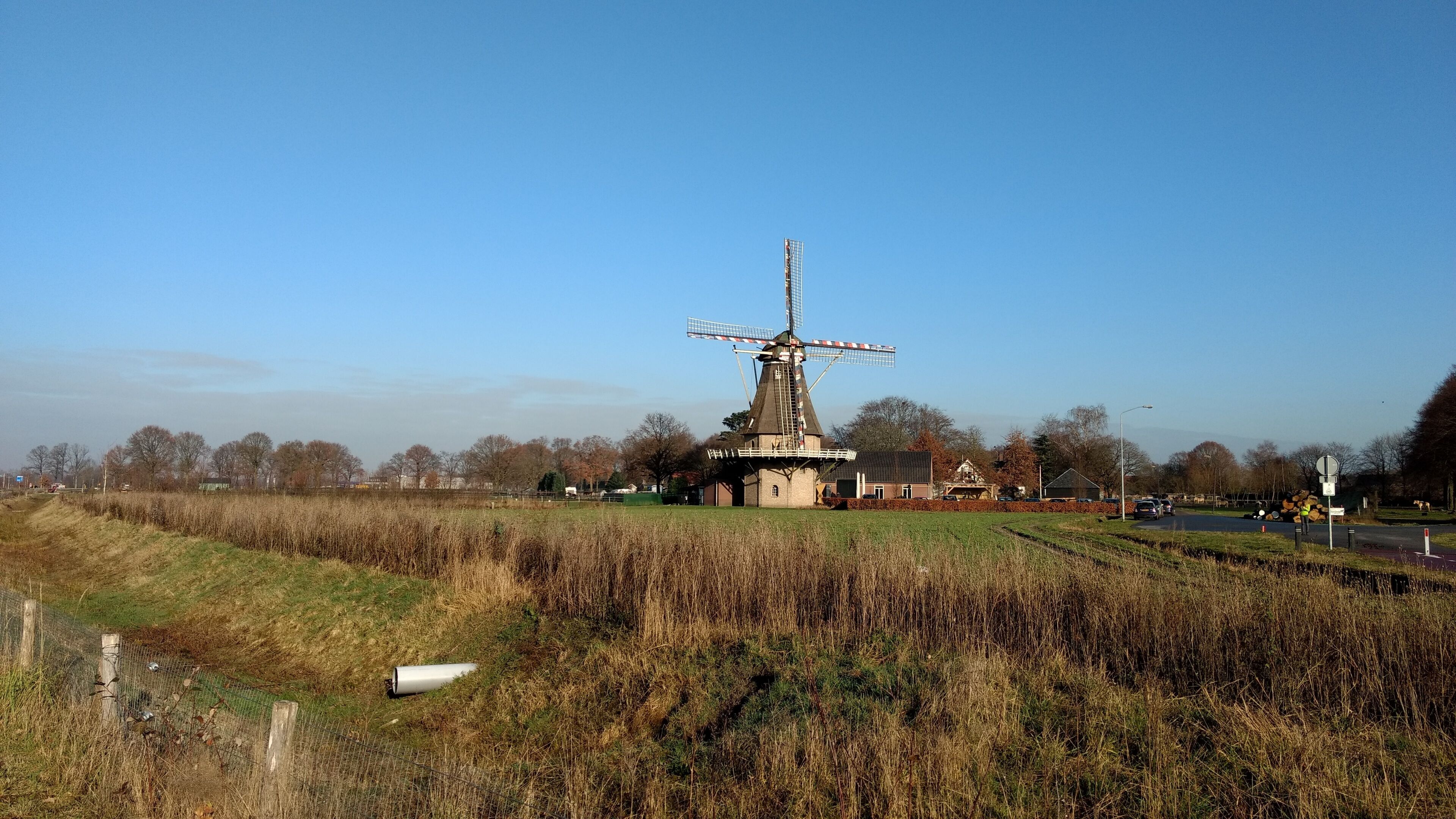 A windmill, a building, and a field.