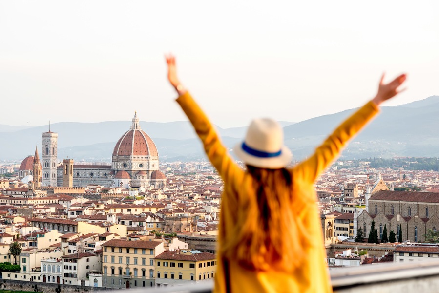 Young female tourist with raised hands looking on the old town of Florence from Michelangelo square in the morning in Italy. Back focus; Shutterstock ID 474019549