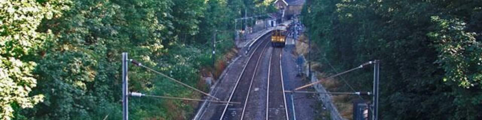 Train leaving Winchmore Hill Station towards Enfield Chase. Looking southwards over the bridge towards Winchmore Hill Station, with a train leaving the station on the northbound track.