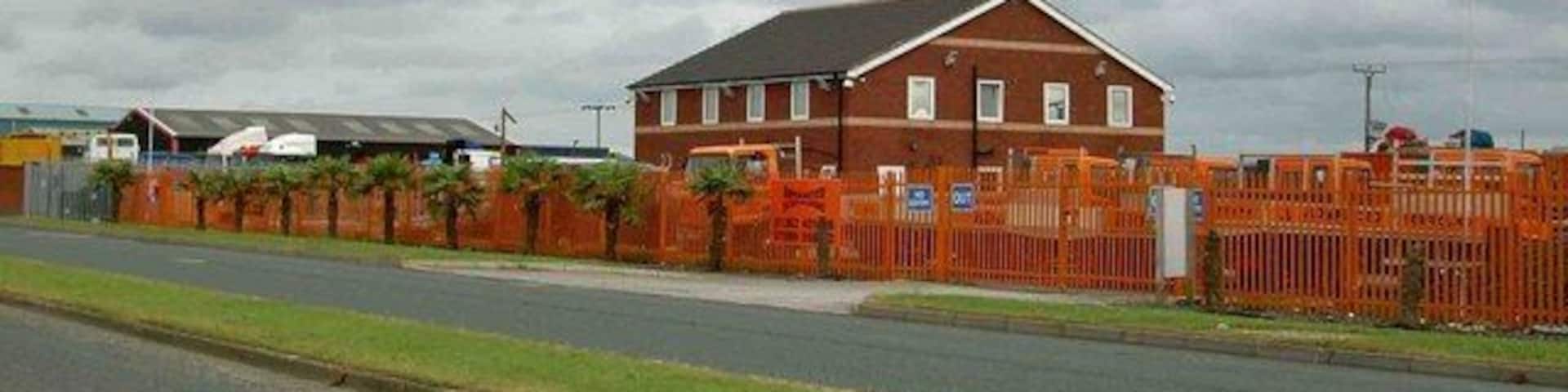 The palm fringed verges of Lancaster Road, Carnaby, East Riding of Yorkshire, England. Advanced Scaffolding's frontage of palms.