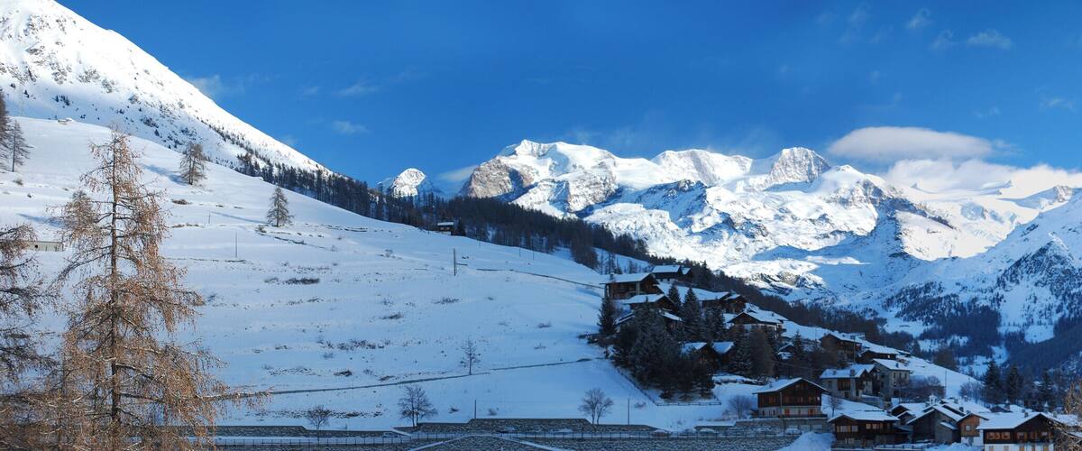 A snow-covered mountain range with a small village nestled among the peaks.