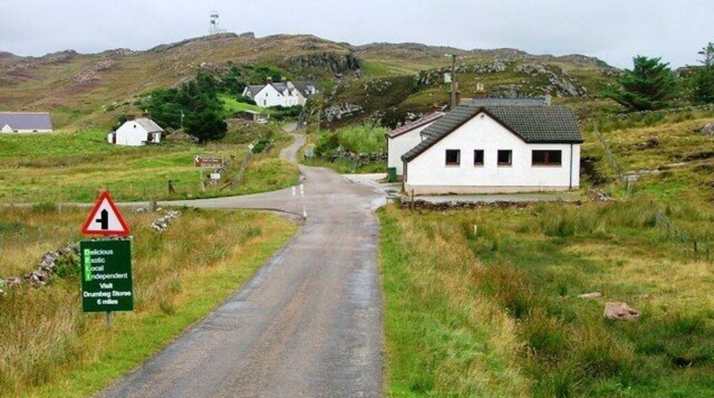 Turn Off to Stoer Lighthouse. The building opposite the junction is the village community hall.