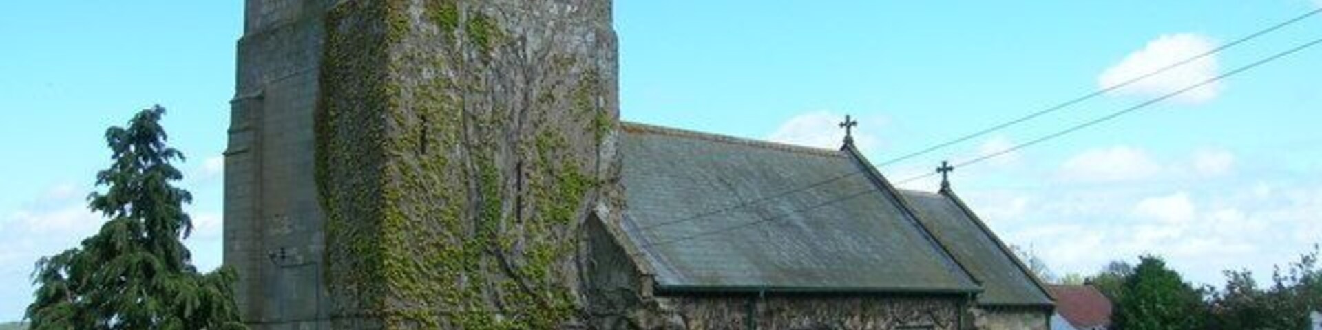 Una iglesia histórica con una torre y un cementerio.