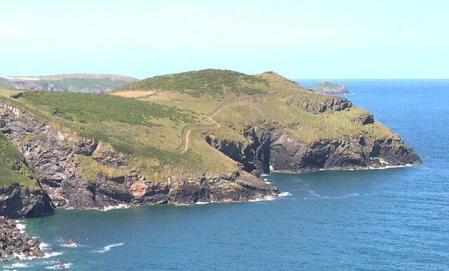A coastal landscape with rocky cliffs and a narrow sea passage.