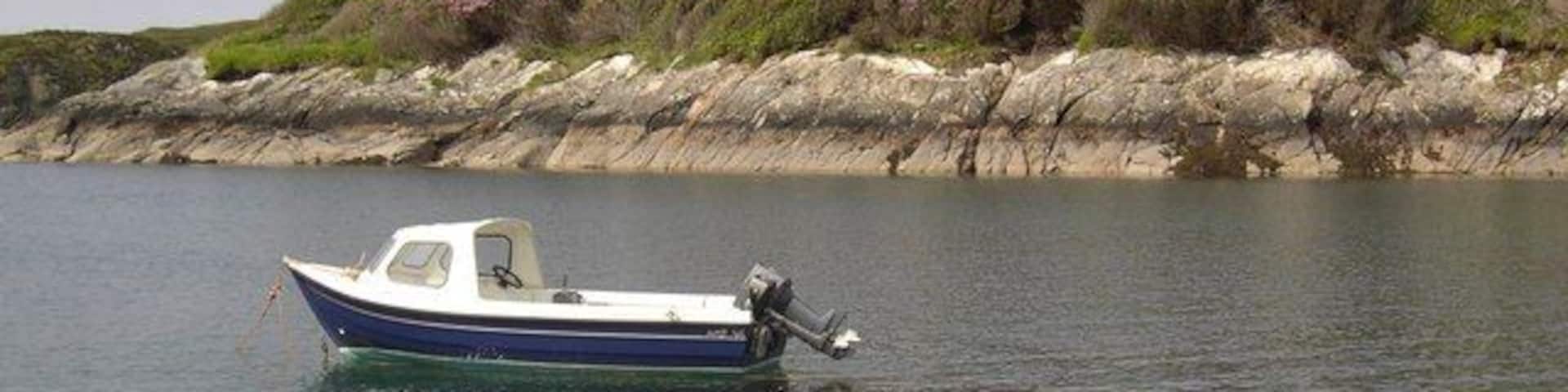 Boat on Loch Leosavay A small boat on Loch Leosavay in front of Abhainnsuidhe Castle.