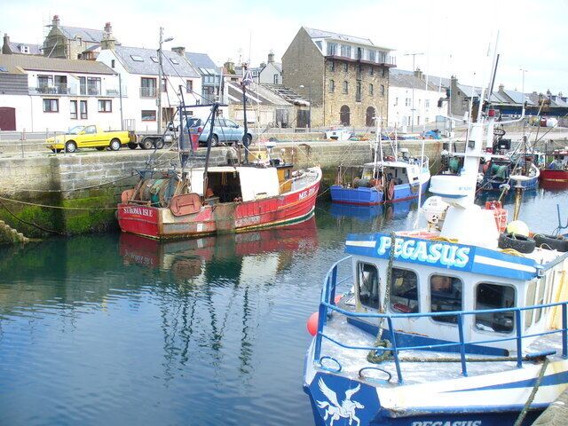 A harbor with several boats, including a blue and white boat named 'PEGASUS'.
