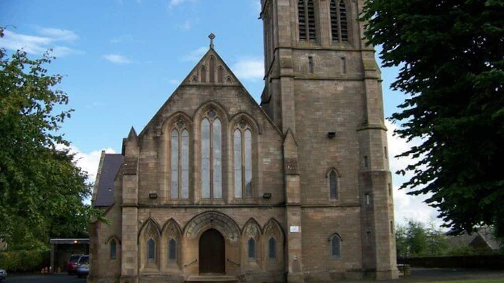 A large stone church with a tall bell tower and arched windows.
