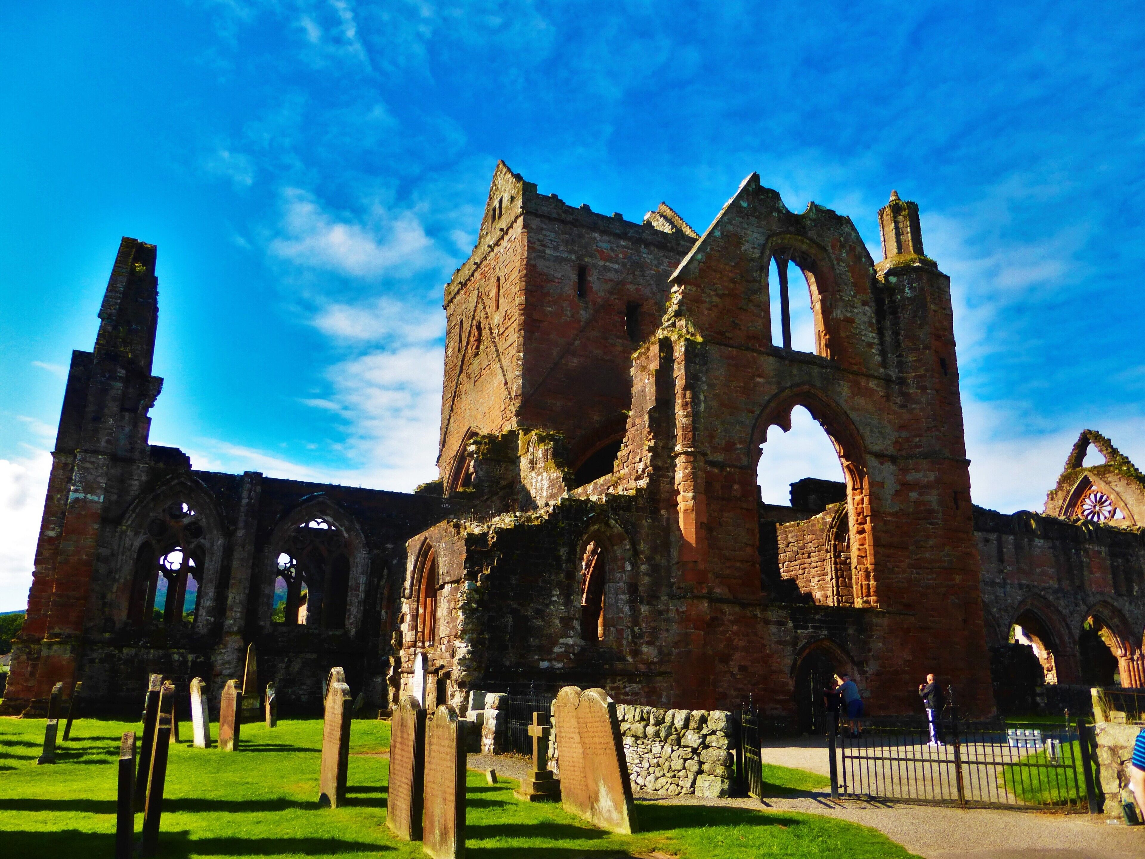An ancient stone church with arched windows and a tall bell tower.