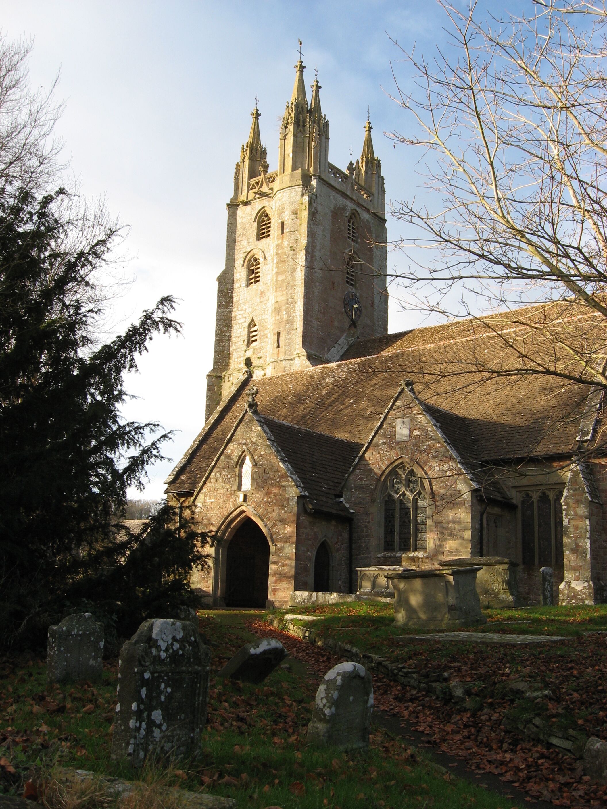 A historic church with a tall tower and a smaller building with arched windows.