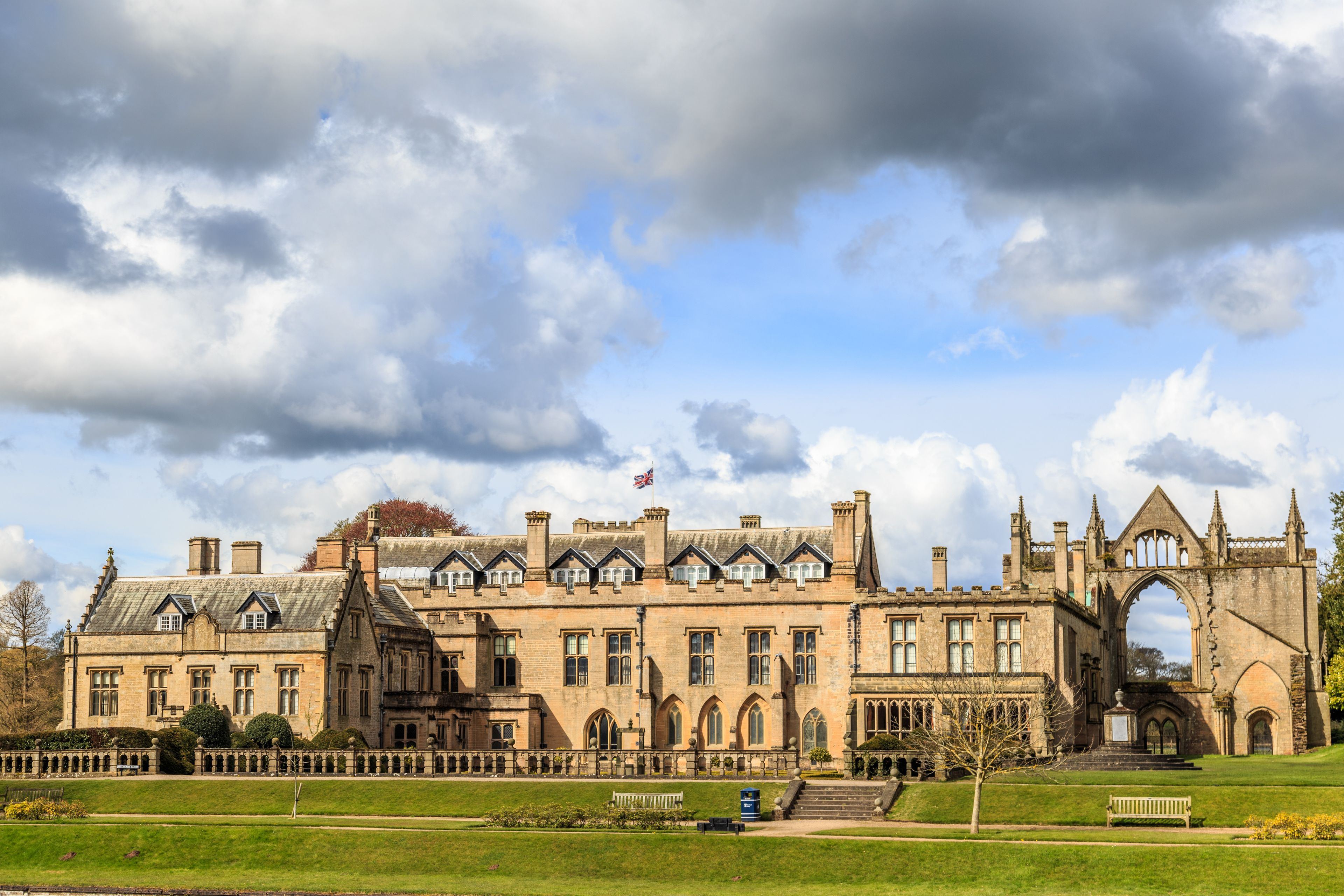 A historic building with a large arched entrance and a flagpole.