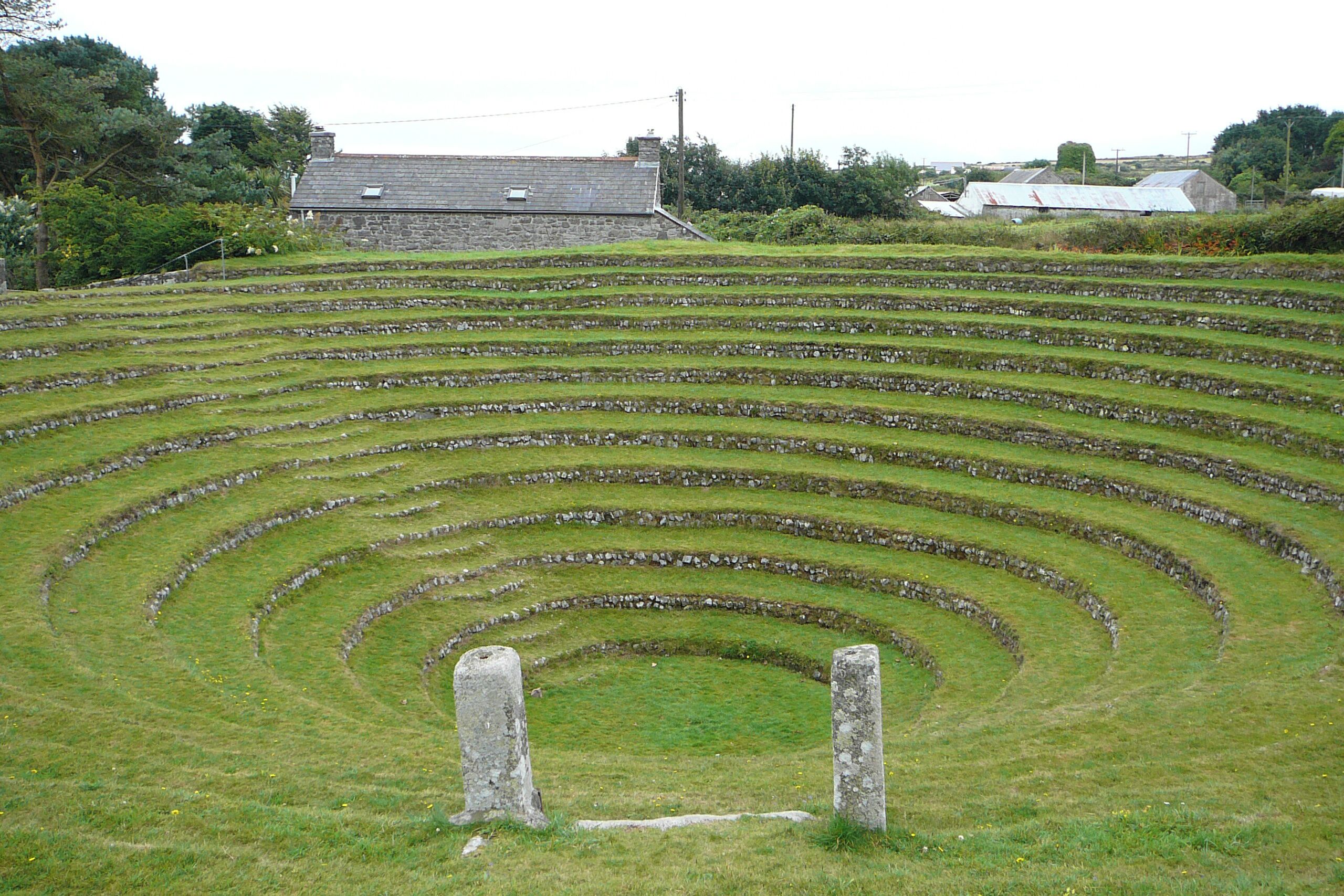 Terraced fields with stone walls and a stone structure in the foreground.