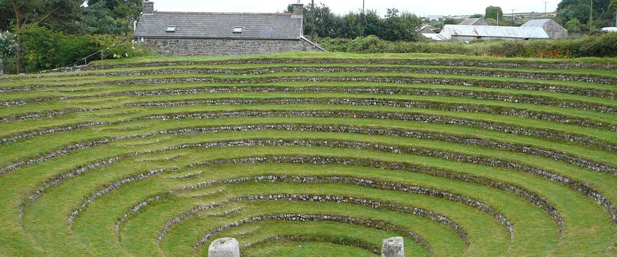 Terraced fields with stone walls and a stone structure in the foreground.