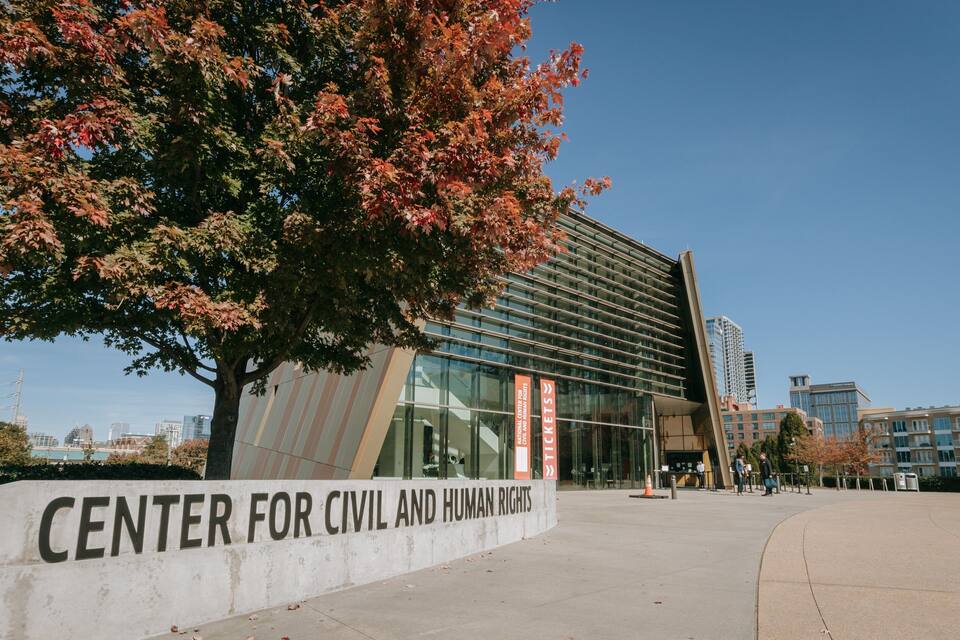 The Center for Civil and Human Rights building with a modern glass facade and a sign in front.